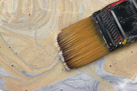 Paint brush in gold paintの写真素材