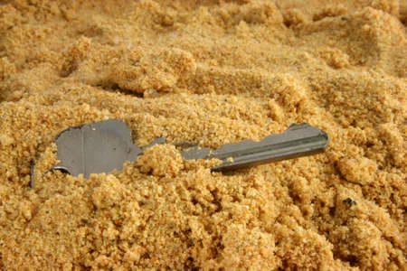 A Key lost on the beach - and buried in the sandの写真素材