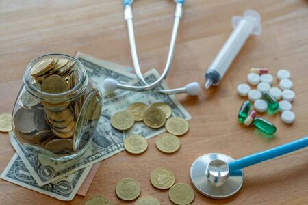 Money such as coins and banknote are on the table with medicines.Dollars for  medical expense with...