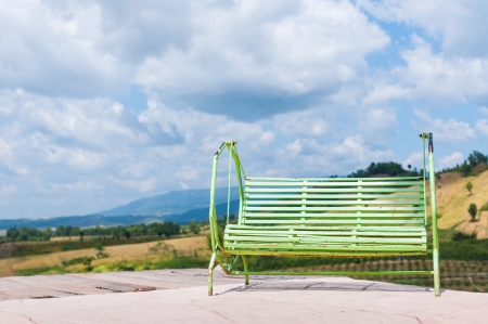 Old green swing with cloudy blackgroundの写真素材
