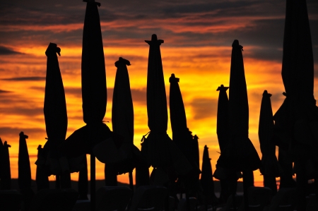 Silhouette of beach umbrella against sunset.の写真素材