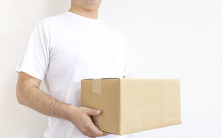 Standing man with cardboard boxの写真素材