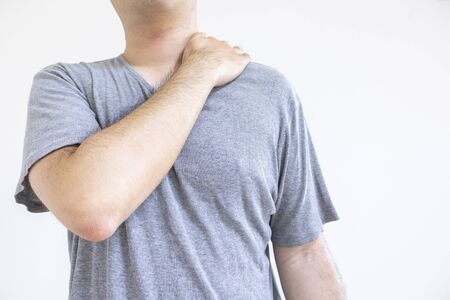 Men holding shoulders with stiff shouldersの写真素材