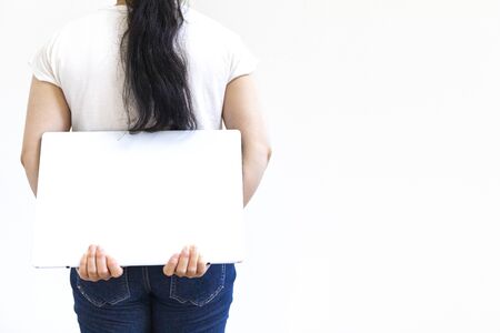 Back view of a woman with a laptop hidden on her backの写真素材