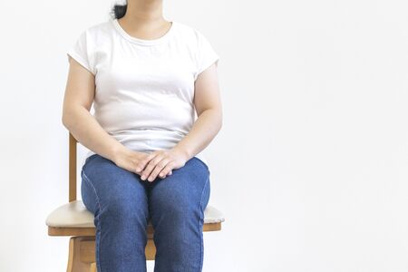 A little fat woman sitting in a wooden chairの写真素材