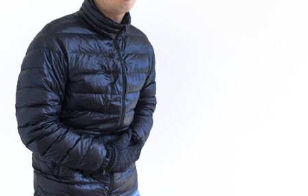A man wearing a down jacket struggling with his stomachの写真素材