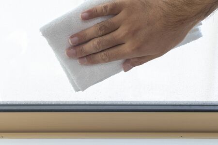 Man's Hand Wiping Window with Towel