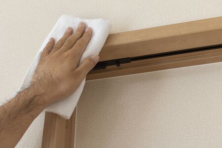 Man's Hand Wiping the Upper Side of Door with Towel