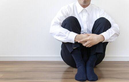 Man in business shirt sitting on the floor and restingの写真素材