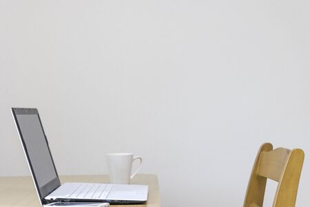 Photo taken from the side of a laptop on a table on a white background