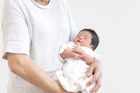 An 18-year-old baby sleeping hugged by a woman in her 60sの写真素材