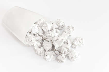 A trash can that has collapsed and spilled paper scrapsの写真素材
