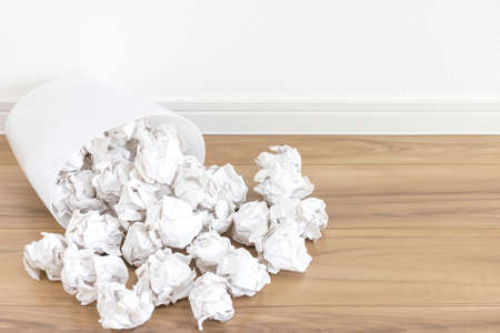 A trash can that has collapsed and spilled paper scrapsの写真素材