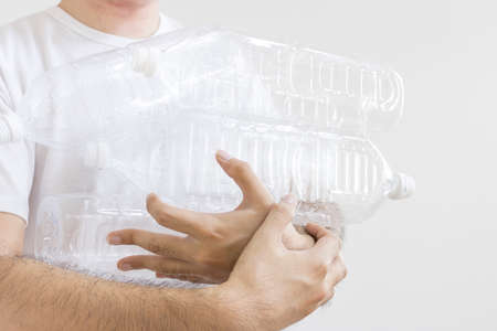 Man holding a lot of empty plastic bottlesの写真素材