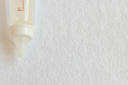 Baby bottle with milk on a white towelの写真素材