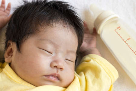Sleeping baby and baby bottleの写真素材