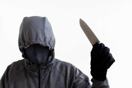A man holding a kitchen knife and hiding his faceの写真素材