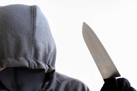 A man holding a kitchen knife and hiding his face