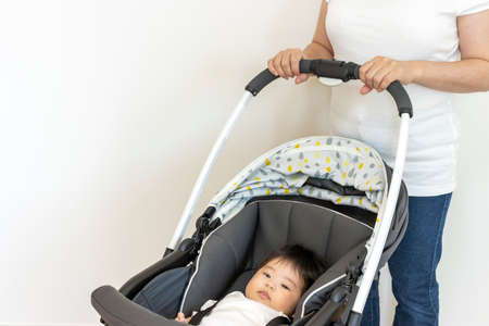 Mother pushing with baby in stroller, 4 months old, girl