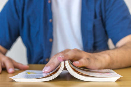 Hands of a man reading on a desk