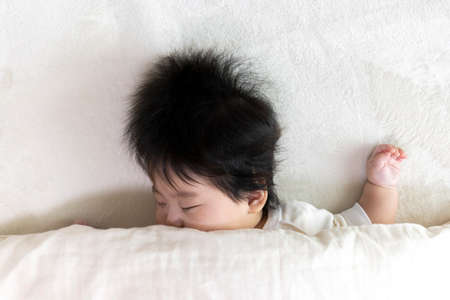 Baby's face sleeping on a futon, 0 years old, 4 months old, girl