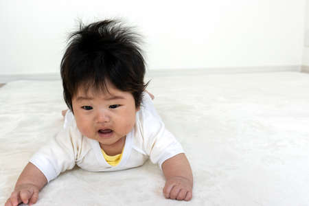 Baby trying to raise his head from prone (0 years old, 4 months old, girl)の写真素材