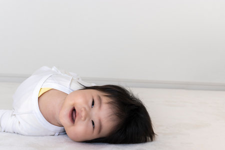 Baby looking at the camera while turning over (0 years old, 5 months old, girl)