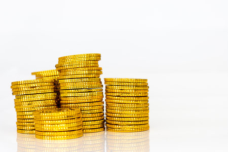 Stacked gold coins, white background, business image, image of savingの写真素材