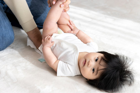 Father changing baby diapers (0 years old, 6 months old, girl, Japanese)の写真素材