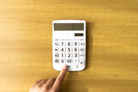 Hands of a man using a calculator (30s, Japanese)の写真素材