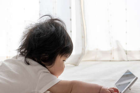 A baby who uses a smartphone. Image of digital native generation (0 years old, 7 months old, girl, Japanese)の写真素材