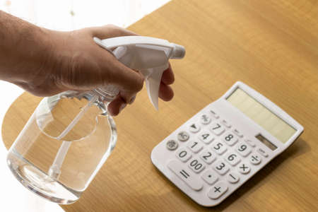 Image of disinfecting a calculator with alcoholの写真素材