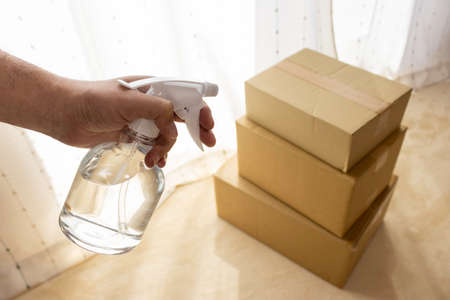 Image of disinfecting cardboard boxes with alcoholの写真素材