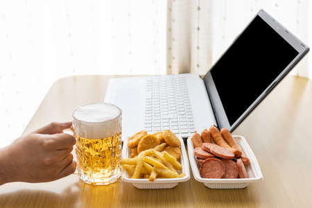 Image of a man having an online drinking party at home using a laptop computer