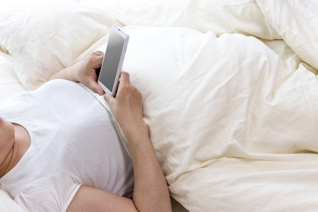Hands of women who use smartphones while sleeping (Japanese, young, 30s)の写真素材