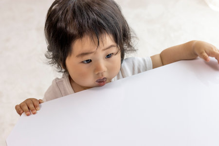 Baby trying to stand at the table (0 years old, 10 months old, Japanese, girl)の写真素材
