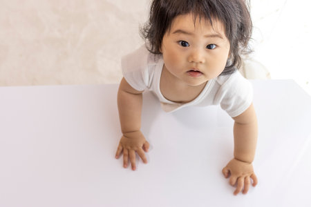 Baby standing at a table (0 years old, 10 months old, Japanese, girl)