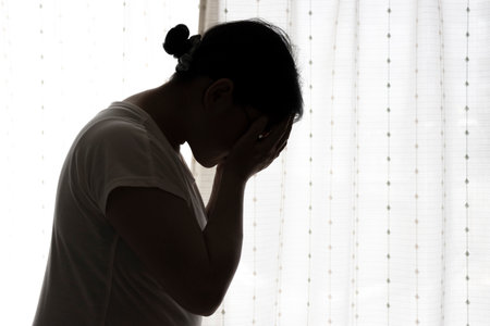 Young woman holding her head (Japanese, 30s)の写真素材