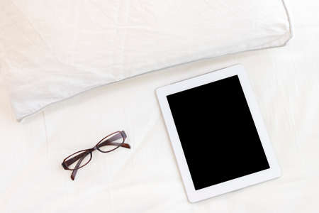 Image of using a tablet device in bedの写真素材