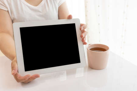 Young woman (Japanese, 30s) showing a tablet deviceの写真素材