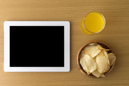 Image of eating a snack during breaks and using a tablet deviceの写真素材