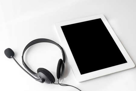 Tablet device and black headphones (white background, wired)