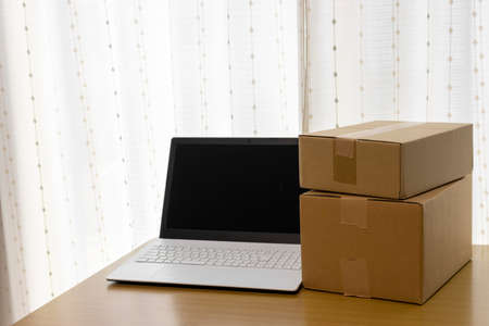 Laptop and cardboard. Mail order, resale, side business, online business imageの写真素材