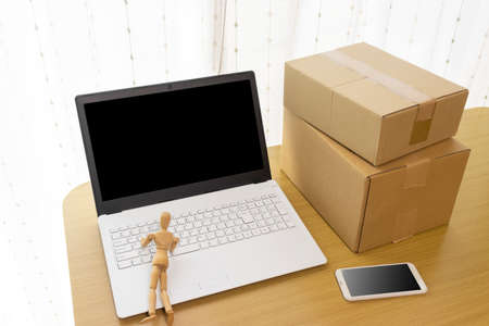 Laptop, cardboard and drawing doll. Internet business automation imageの写真素材