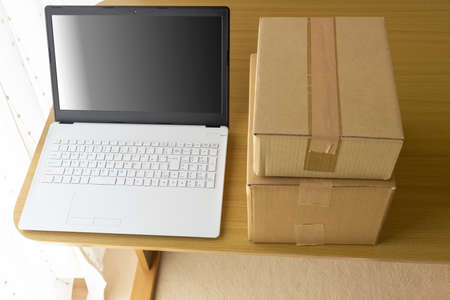 Laptop and cardboard. Mail order, resale, side business, online business imageの写真素材