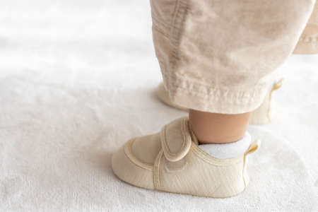 Standing baby's feet wearing baby shoes (1 year and 2 months old, girl, Japanese)の写真素材