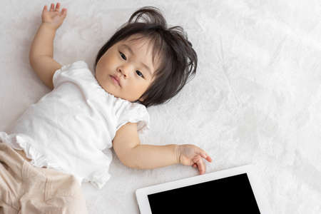 Baby and tablet device (1 year and 2 months old, Japanese, girl)の写真素材