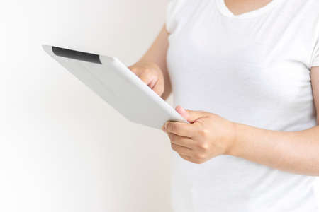 Image of a woman using a tablet device (30s, Japanese, no face)の写真素材