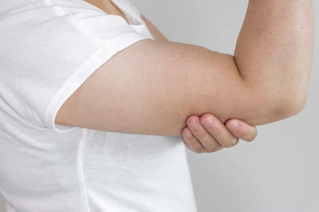 A woman holding her upper arm (Japanese, 30s, no face)の写真素材