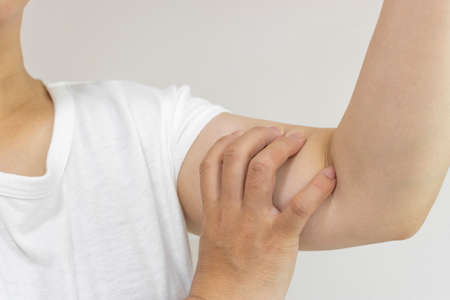 A woman holding her upper arm (Japanese, 30s, no face)の写真素材